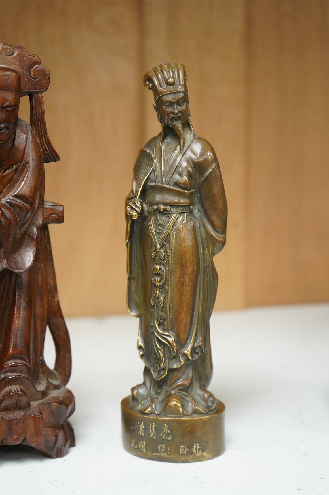 A bronzed Chinese figure of Qianlong, a carved bamboo brush pot and a hardwood figure, largest 20cm high
